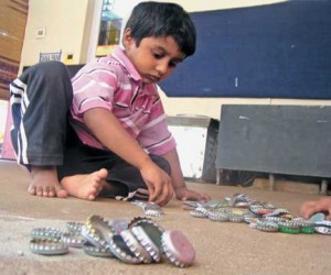 boy-playing-with-bottle-caps